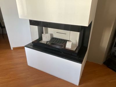 une cheminée dans un coin d'une pièce, sur laquelle est posée une télévision