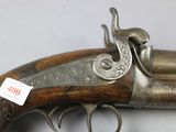 an old gun with a wooden handle on a white surface