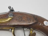 an old gun with a brass handle on a white surface