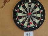 a dart on the wall next to a dart board