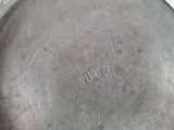 an old silver plate sitting on top of a stove top oven