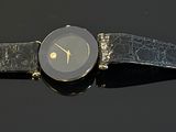 a close up of a watch on a black surface