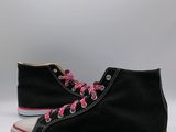 black high top sneakers with pink laces on a white background
