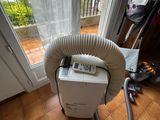 a small air conditioner sitting on the floor in front of a window