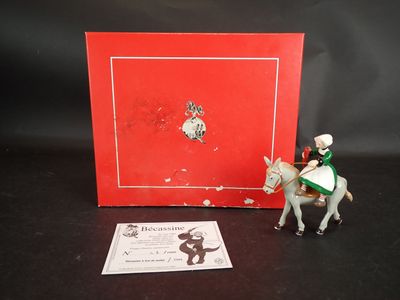 une petite figurine représentant un homme à cheval, à côté d'une boîte rouge