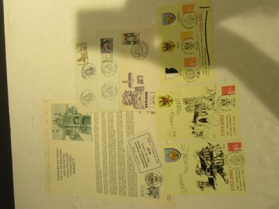 a shadow of a person holding a cell phone in front of some postcards