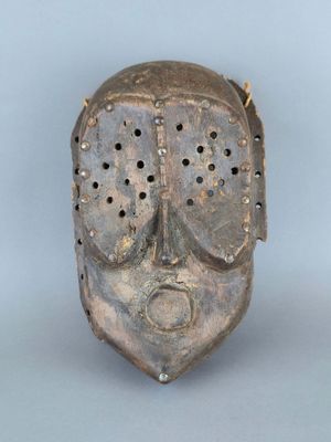 un gros plan d'un masque métallique percé de trous