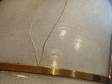 a close up of a white vase with a gold band