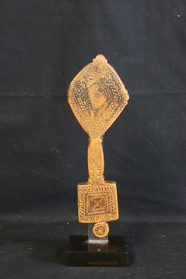 a gold trophy on a black surface with a black background