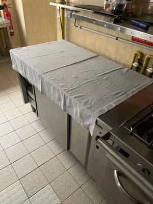 une cuisine équipée d'une cuisinière, d'un four et d'une table recouverte d'un drap