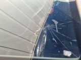 a broken window of a car that is parked on the side of the road