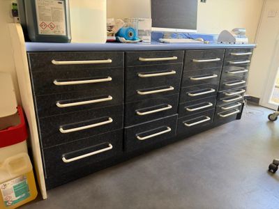 une armoire noire avec de nombreux tiroirs dans une pièce