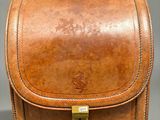 an image of a brown leather bag on a grey background