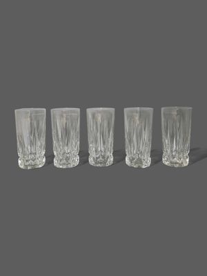 four glasses are lined up in a row on a gray surface