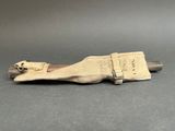 a close up of a knife on a table with a canvas bag