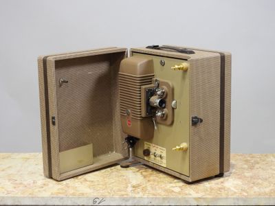an old camera sitting on a table with its door open