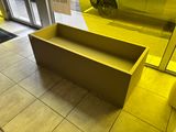 a yellow bench in the middle of a tiled floor