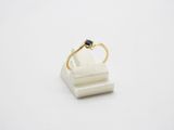 a gold ring with a black diamond sits on top of a white marble block