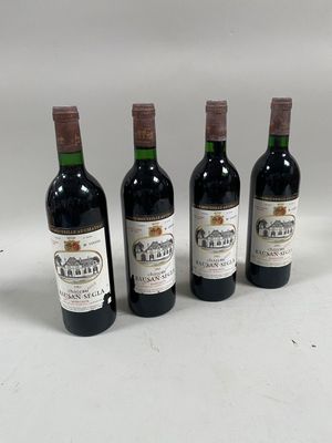 quatre bouteilles de vin sont alignées sur une surface blanche