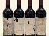 three bottles of wine are lined up on a white surface
