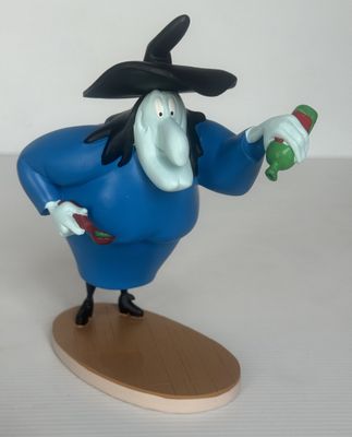 une figurine représentant un sorcier tenant une bouteille de vin