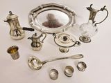a silver plate and silverware on a white table