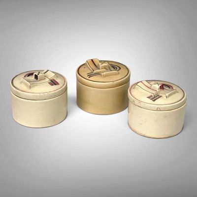 three round tins with lids are sitting on a gray surface