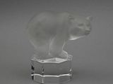 un ours en verre posé sur un bloc de verre