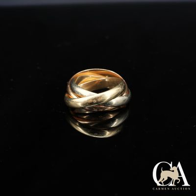 gros plan d'une bague en or sur une surface noire