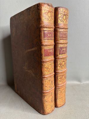deux vieux livres posés l'un sur l'autre sur une table