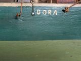 a close up of a piece of wood with the word dora painted on it