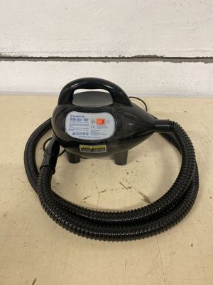 a black blow dryer sitting on top of a table next to a wall