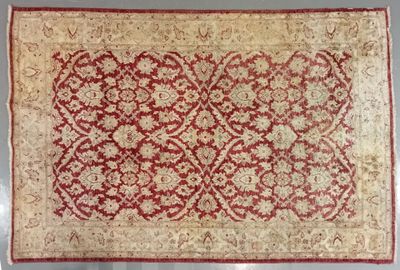 a red and beige rug with a floral design on it