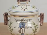 un pot en céramique orné d'un soldat, posé sur une table
