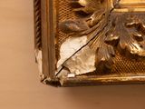 a close up of a gold frame with a bird on it