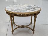 une table au plateau en marbre posée sur un piètement doré