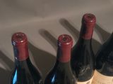 four bottles of wine are lined up on a table
