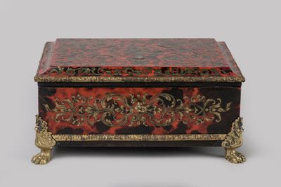 une boîte rouge et noire ornée de motifs dorés