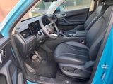 the interior of a blue car with black leather seats and a steering wheel