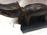 une petite statuette représentant un chien avec une médaille autour du cou
