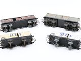 four model train cars are lined up on a white surface