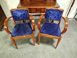 une paire de fauteuils recouverts de velours bleu, placés devant un miroir