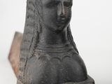 pair of black stone busts of a woman and a man on a white background