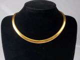 un gros plan d'un collier en or sur un mannequin