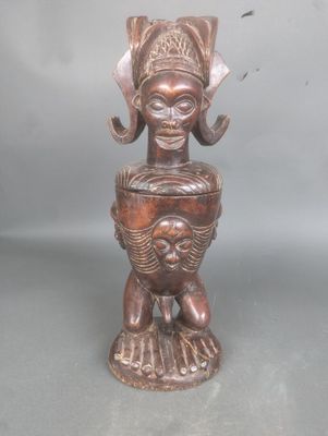 une image représentant une statue en bois d'une femme tenant un bébé dans ses bras