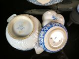 a small group of blue and white teapots and saucers