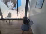 two chairs in the corner of a room with a picture on the wall