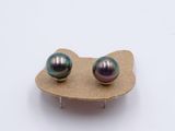 a pair of earrings that are on top of a piece of cardboard