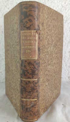 an old book sitting on top of a table next to a white wall