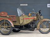 a motorcycle with a side car parked in front of a garage